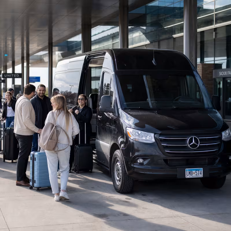 Group boarding a white charter bus for Airport Transportation transportation in Sioux Falls